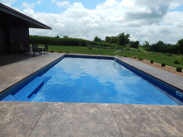 A swimming pool surrounded by gray tiles